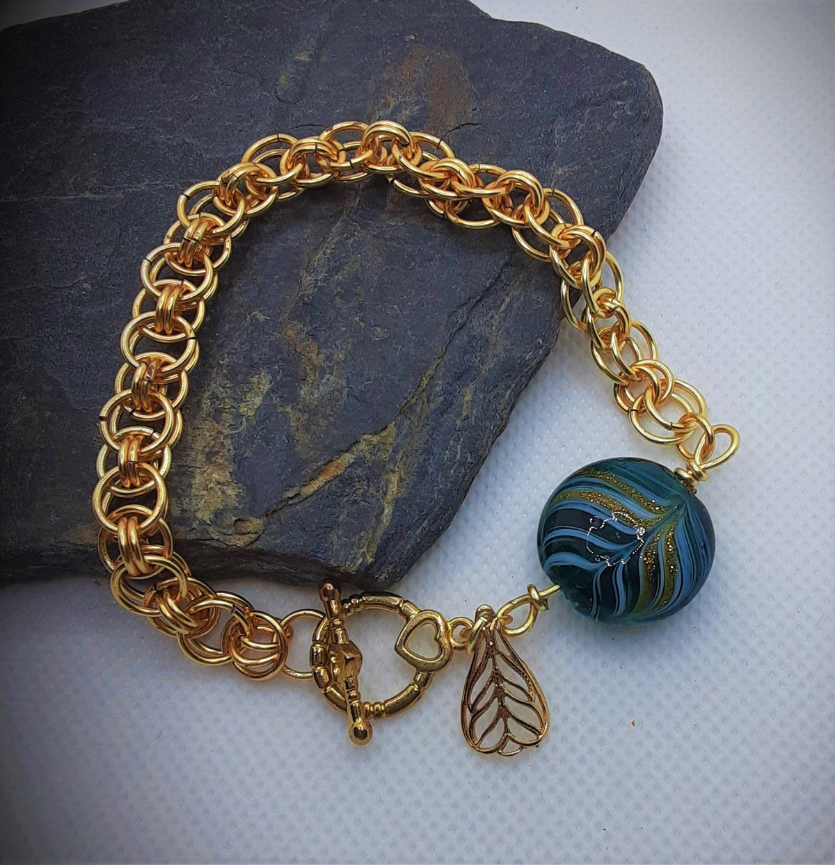 Gold tone chain mail bracelet with green bead