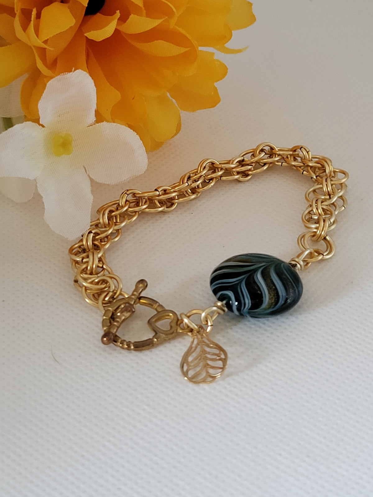 Gold tone chain mail bracelet with green bead